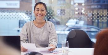 Portrait Of Smiling Asian Businesswoman Sitting At Table In Office  Meeting Room