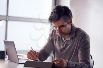 Businessman Working From Home Drawing On Digital Tablet Using Stylus Pen