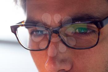 Close Up Of Businessman Wearing Glasses Looking At Computer Screen