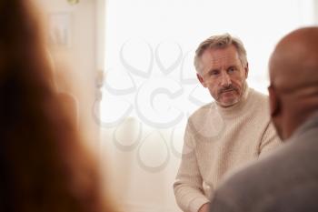 Mature Man Attending Support Group Meeting For Mental Health Or Dependency Issues In Community Space
