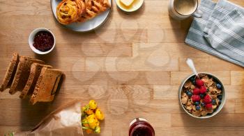 Overhead Flat Lay Shot Of Table Laid For Breakfast With Toast Cereal Croissant Pastries And Flowers