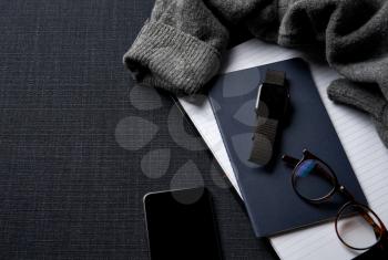 Flat Lay Lifestyle Shot With Jumper Smartwatch Notebook And Mobile Phone On Black Background