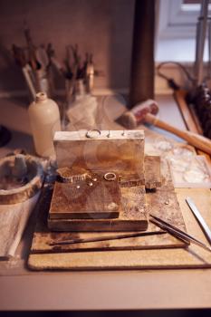 Close Up Of Jewellers Workbench With Tools And Designs  In Studio