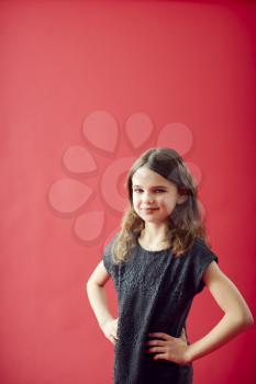 Portrait Of Girl Against Red Studio Background Smiling At Camera