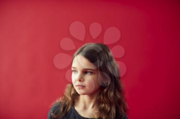 Portrait Of Girl Against Red Studio Background Smiling At Camera