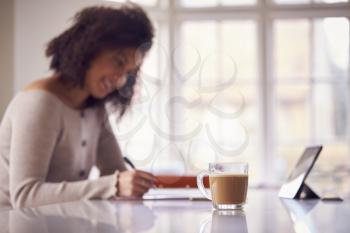 Woman With Digital Tablet Working From Home On Kitchen Counter