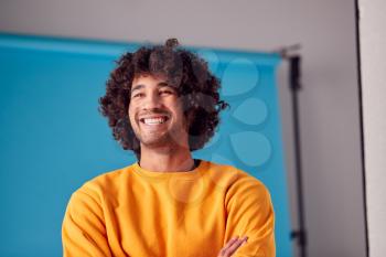 Studio Portrait Of Smiling Young Man Against Blue Background
