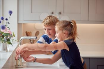 Two Children Washing Hands With Soap At Home To Prevent Spread Of Infection In Health Pandemic