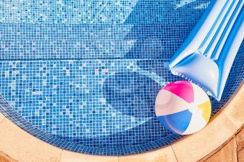 Overhead Shot Of Inflatable Airbed And Beach Ball Floating In Outdoor Swimming Pool