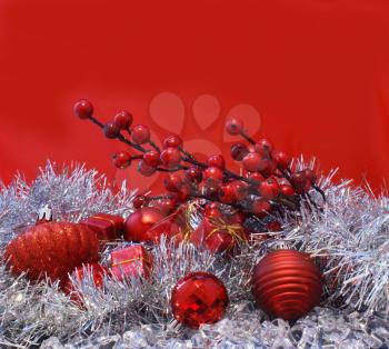 Christmas berries, baubles and gifts on a red background