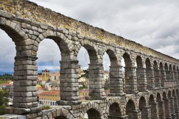 The well-known antique aqueduct and ancient Segovia in cloudy May day

