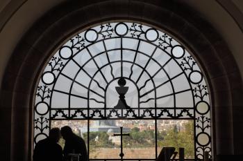 Jerusalem, photographed through a stained-glass window, and the silhouettes of two parishioners
