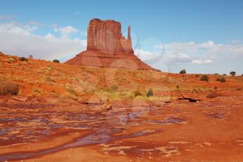 The majestic Monument Valley. Puddles after the rain among 'Mittens'