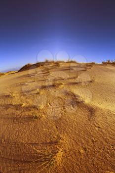 Sandy dunes at coast of Mediterranean sea on a sunset