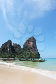 Magic beach on island. Picturesque native boats Longtail expect the first morning tourists
