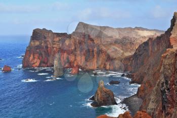 Red rocks and blue sea. Eastern end of Madeira Island at sunset. Deep Bay with picturesque islands - rocks