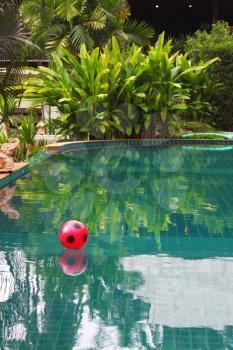 Red beach ball floating in pool luxury hotel. Koh Samui
