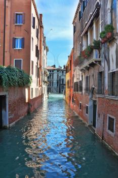 Eternal fantastic Venice. Narrow street - channel. In water the dark blue sky is reflected