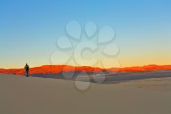 Sunrise in sandy dunes of Death valley in the USA. The professional photographer prepares for photographing