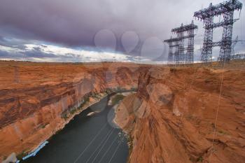  An abrupt bend of the river Colorado and metal support with electricity cables in state of Utah in the USA