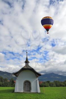 Balloon over the lovely white village chapel. Southern France