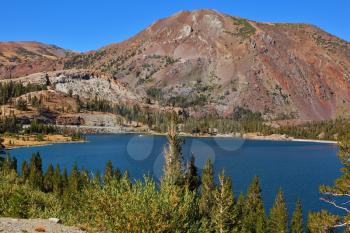 Lake Tioga on pass in an environment of picturesque mountains. Warm serene autumn day in Yosemite park of the USA, California