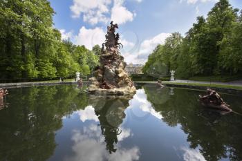 Classical figures decorate a fountain in magnificent park reflection