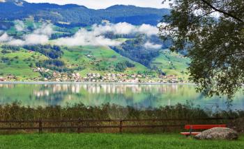  Wonderful lake in the Swiss Alpes, village and a red bench