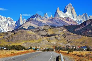 Famous rock Fitz Roy peaks in the Andes. Magnificent panorama of snow-capped mountains in Patagonia. To mountains leads the asphalt road
