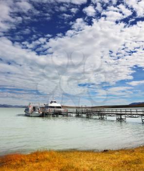   The lake in Argentina and tourist boat at the pier. Journey into a far country