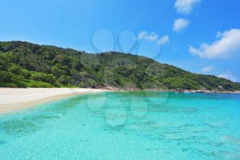 The picturesque shores of magical Similan Islands. Delicate white sand beach surrounded by thick tropical green forest