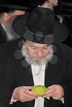 BENE - BERAK, ISRAEL - SEPTEMBER 17, 2013:  The elderly man with gray-haired beard chooses a citrus.  Big market on the eve of the Jewish holiday of Sukkot