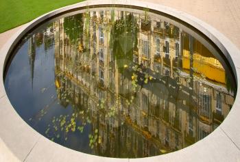 Reflection of hotel in an oval small reservoir in resort city Montreux in Switzerland