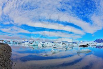Jökulsárlón Glacial Lagoon in Iceland. Cirrus clouds are beautifully reflected in the smooth water of the ocean lagoon