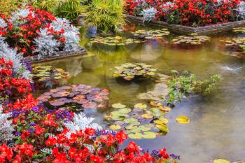 Delightful landscaped and floral park Butchart Gardens on Vancouver Island. Small pond, overgrown with flowers