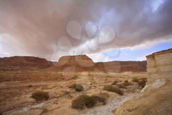 Huge cloud of the freakish form above stone desert. Spring on the Dead Sea