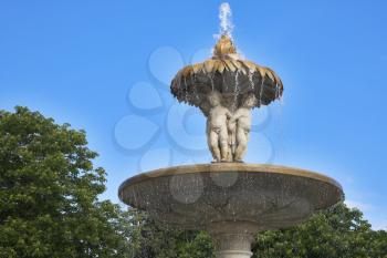 The picturesque fountain decorated by marble statues, in park of Madrid