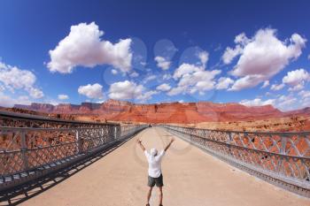 The enthusiastic tourist welcomes solar midday over the bridge through the river Colorado

