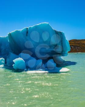 Argentina Patagonia, Lake Viedma. The huge white-blue iceberg departures from a coastal glacier in warm summer day
