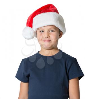 Charming seven-year boy in Santa Claus hat cheerfully smiles. Photo executed on a white background
