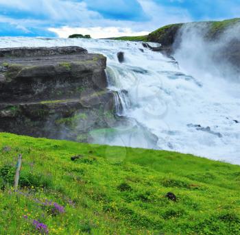 Powerful high-water waterfall in Iceland. For walks and observations on the hillside laid convenient path