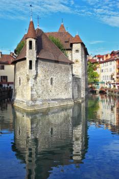 Clear early morning. The bastion turned into prison, is reflected in channel water. The charming ancient city of Annecy in Provence
