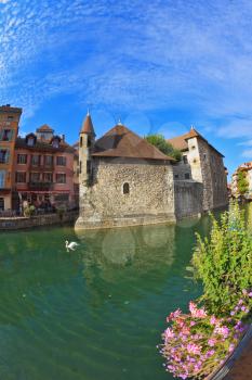 Charming old town of Annecy in Provence. Bastion- prison turned into  museum, is reflected in the water channel. Clear early morning