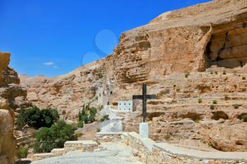 The road leading to the temple. Sacred George Hozevit's well-known monastery. The monastery is constructed to Vadi Kelt's gorges in vicinities of Jerusalem.  The guiding signpost - Black Cross
