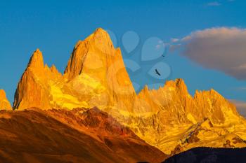 Fiery sunset illuminates the spectacular cliffs Fitz Roy. The stunning Patagonia
