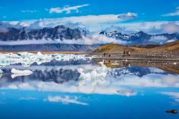  Ocean Bay is surrounded by volcanic mountains and glaciers. Icebergs and ice floes are reflected in the mirrored water. Ice lagoon in Iceland