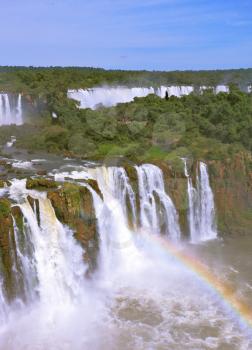 The magnificent rainbow costs over roaring water streams. The best-known falls in the world - Iguazu.  Brazilian party.
