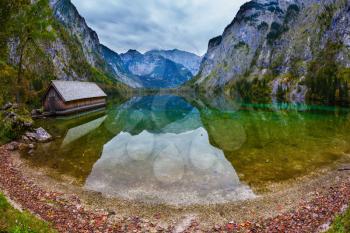 The concept of active tourism and ecotourism. Enchanted Lake Obersee in the Bavarian Alps. Boat garages on the shores 
