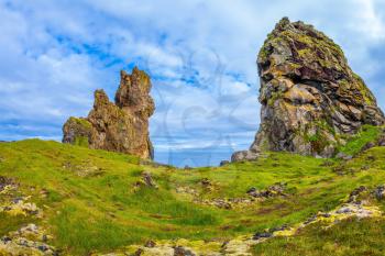 The picturesque ancient rocks covered with a green and yellow moss. Magnificent Iceland. Northern sea coast 