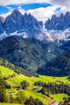 Lovely sunny day in Naturpark Puez-Odle.  Dolomites, Val de Funes valley. Odle mountain peaks around the green alpine meadows of the valley